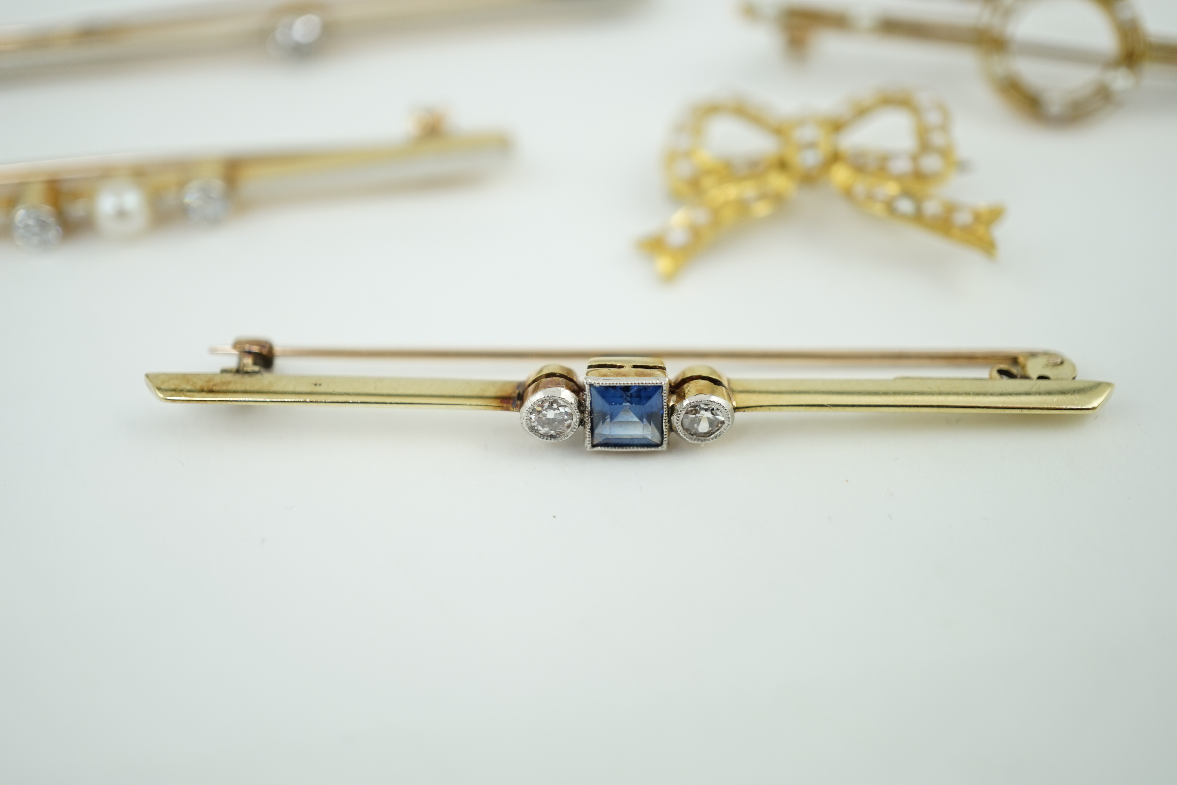 Five assorted Edwardian bar brooches, including a 15ct gold sapphire and diamond set three stone, a diamond and seed pearl, ruby? and seed pearl, a solitaire diamond set and a seed pearl and citrine bug brooch